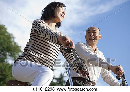 Mature couple riding bicycle View Large Photo Image Stock Photo - Mature couple riding bicycle. Fotosearch