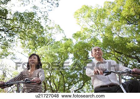 Stock Photo - Mature couple riding bicycle. Fotosearch
