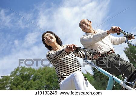 Mature couple riding bicycle View Large Photo Image Stock Photograph - Mature couple riding bicycle. Fotosearch