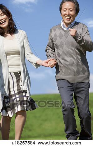 Picture - Mature Couple Running in Field. Fotosearch