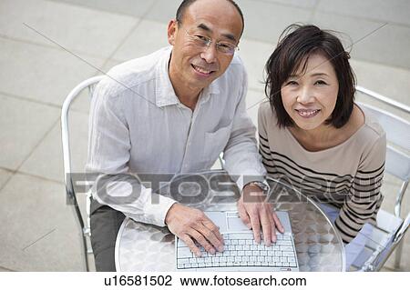 Mature couple using laptop outdoors View Large Photo Image Stock Image - Mature couple using laptop outdoors. Fotosearch