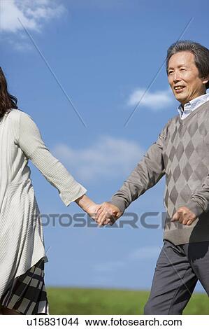Mature Man Couple Holding Hands and Walking in Field View Large Photo Image Picture - Mature Man Couple Holding Hands and Walking in Field. Fotosearch