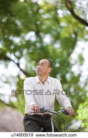 Mature man riding a bicycle View Large Photo Image Stock Photo - Mature man riding a bicycle. Fotosearch