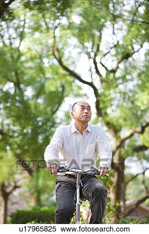 Stock Photography - Mature man riding a bicycle. Fotosearch