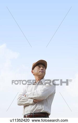 Stock Image - Mature man standing outdoors. Fotosearch