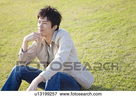 Mid Adult Man Sitting on Grass View Large Photo Image Stock Photo - Mid Adult Man Sitting on Grass. Fotosearch