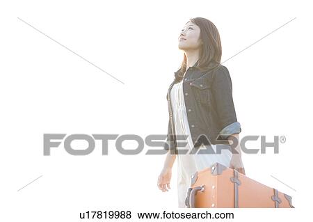 Stock Photo - Mid Adult Woman Carrying Luggage. Fotosearch