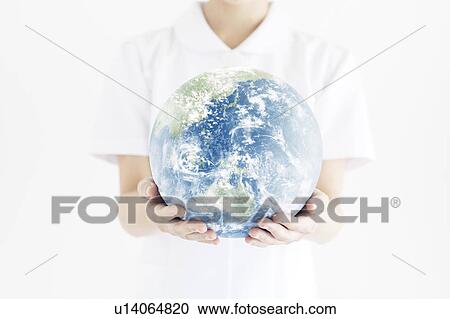 Stock Image - Mid Adult Woman Holding Globe. Fotosearch