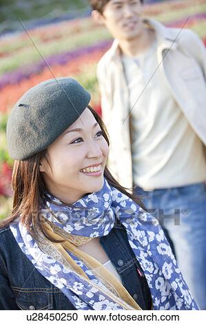 Stock Image - Mid adult Woman, Man in Background. Fotosearch