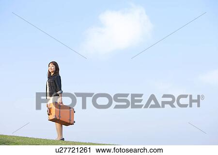 Stock Image - Mid Adult Woman with Luggage. Fotosearch