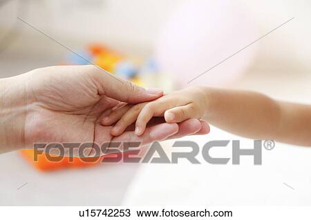 Stock Image - Mother and daughter holding hands. Fotosearch