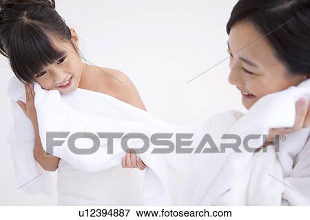 Stock Photo - Mother and daughter wiping face with towel. Fotosearch