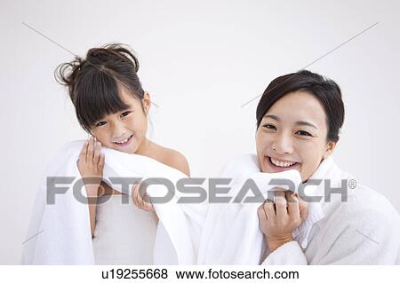 Stock Photo - Mother and daughter wiping face with towel. Fotosearch