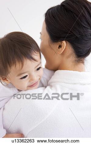 Stock Image - Mother carrying a baby girl. Fotosearch
