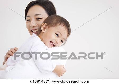Stock Image - Mother carrying a baby girl. Fotosearch
