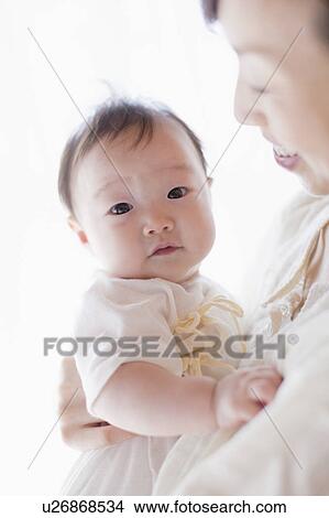 Mother carrying a baby View Large Photo Image Picture - Mother carrying a baby. Fotosearch