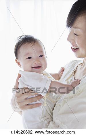 Mother carrying a baby View Large Photo Image Stock Image - Mother carrying a baby. Fotosearch