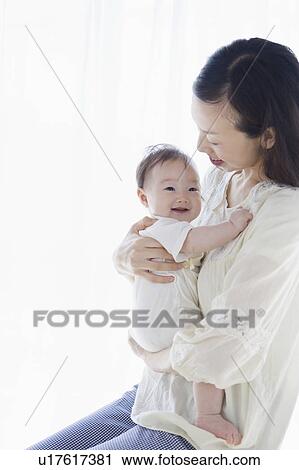 Mother carrying a baby View Large Photo Image Stock Image - Mother carrying a baby. Fotosearch