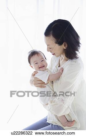 Mother carrying a baby View Large Photo Image Stock Image - Mother carrying a baby. Fotosearch