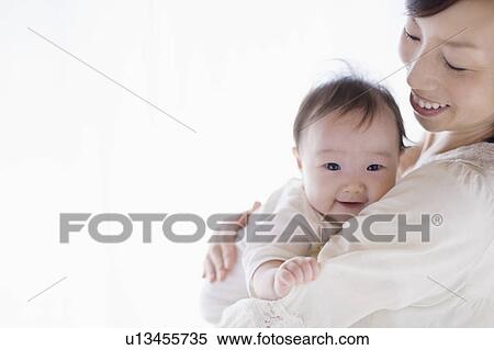 Stock Photography - Mother carrying a baby. Fotosearch