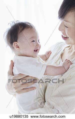 Stock Photography - Mother carrying a baby. Fotosearch