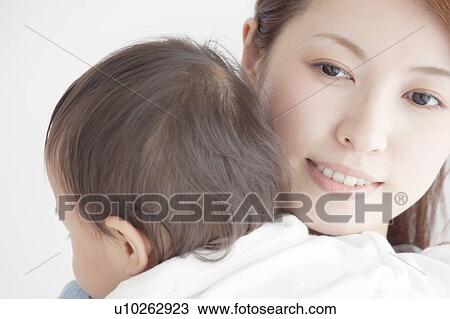 Stock Image - Mother Carrying Baby. Fotosearch