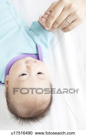 Stock Image - Mother Holding Baby Girl's hand. Fotosearch