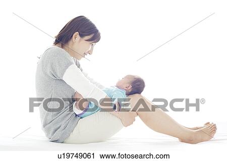 Stock Image - Mother Holding Newborn Baby on Her Lap. Fotosearch