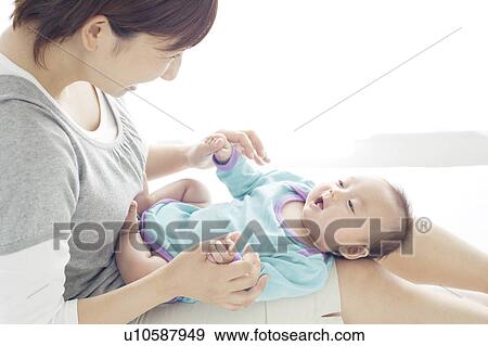 Stock Photo - Mother Holding Newborn Baby on Her Lap. Fotosearch