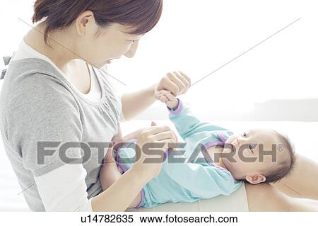 Stock Photography - Mother Holding Newborn Baby on Her Lap. Fotosearch