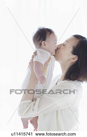 Mother kissing a baby View Large Photo Image Stock Image - Mother kissing a baby. Fotosearch