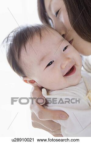 Mother kissing a baby View Large Photo Image Stock Image - Mother kissing a baby. Fotosearch
