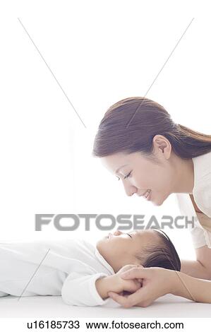 Stock Image - Mother Looking at Sleeping Baby. Fotosearch