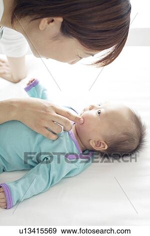Stock Photo - Mother Touching Baby's Cheek. Fotosearch