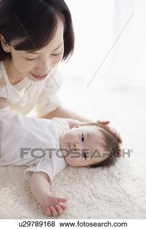 Mother touching baby's head View Large Photo Image Stock Photo - Mother touching baby's head. Fotosearch
