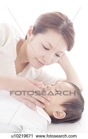 Stock Image - Mother Touching Cheek of Baby Boy. Fotosearch