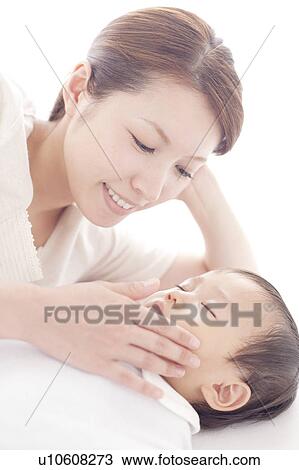 Stock Image - Mother Touching Cheek of Baby Boy. Fotosearch
