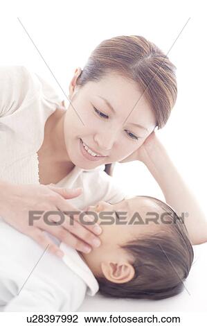 Stock Image - Mother Touching Cheek of Baby Boy. Fotosearch