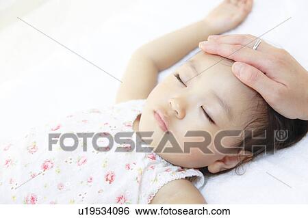 Stock Photograph - Mother touching sleeping daughter. Fotosearch