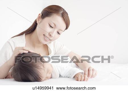 Stock Image - Mother Watching Baby Boy Sleeping. Fotosearch