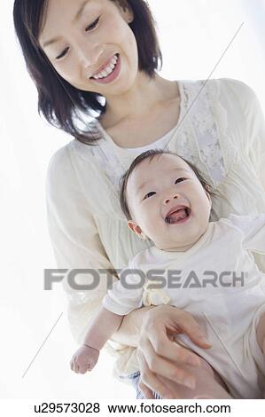 Stock Photo - Mother with baby on a lap. Fotosearch