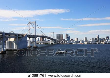 Stock Image - Rainbow bridge and Skyline of Chuo ward, Tokyo, Honshu, Japan. Fotosearch