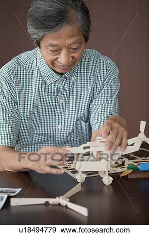 Stock Photo - Senior Man Building Wooden Models. Fotosearch