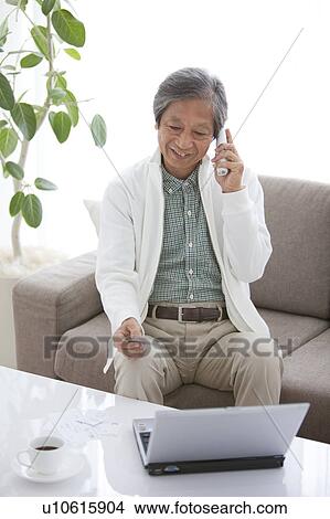 Senior Man Internet Shopping and Talking on Phone View Large Photo Image Picture - Senior Man Internet Shopping and Talking on Phone. Fotosearch