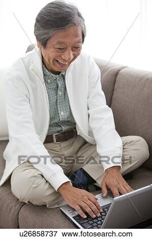 Senior Man Using Laptop on Sofa View Large Photo Image Stock Photo - Senior Man Using Laptop on Sofa. Fotosearch