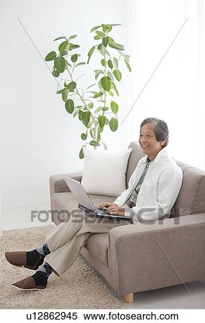 Senior Man Using Laptop on Sofa View Large Photo Image Stock Photography - Senior Man Using Laptop on Sofa. Fotosearch
