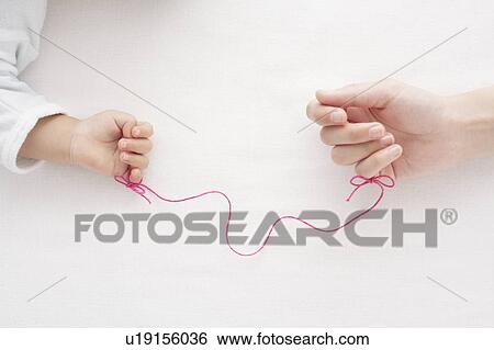 Stock Photograph - Thread Tied Around Baby's and Mother's Fingers. Fotosearch