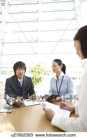 Stock Image - Three Businesspeople Having Meeting. Fotosearch