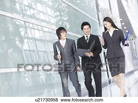 Three Businesspeople Talking and Walking View Large Photo Image Stock Photo - Three Businesspeople Talking and Walking. Fotosearch