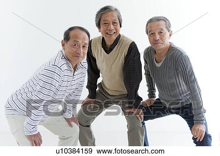 Stock Photo - Three Cheerful Senior Men Crouching. Fotosearch